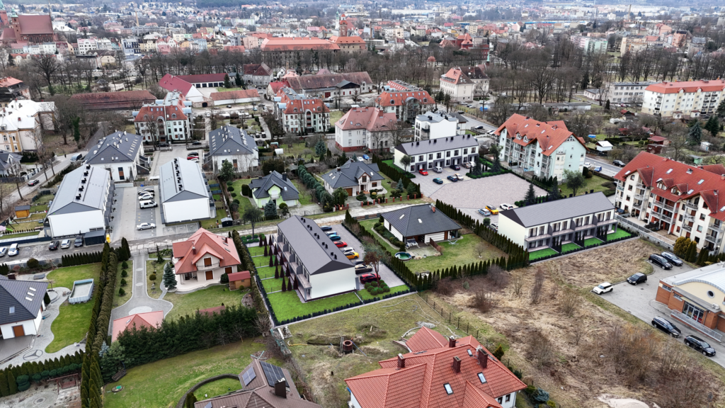Zdjęcie lotnicze osiedla domów jednorodzinnych i okolicznej zabudowy.